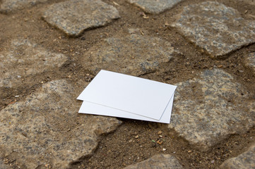 empty mockup business cards stacked on cobblestone flooring 