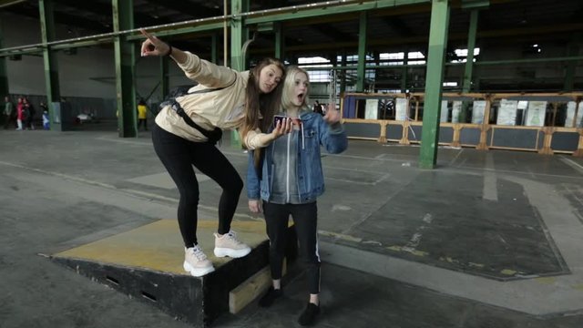 Two girls stand in a hangar and discuss the project
