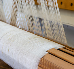 Linen yarn wound on the warp beam of a wooden hand weaving loom