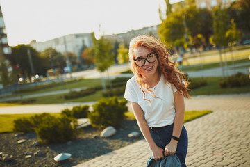 Portraits of a charming red-haired girl with a cute face. Girl posing for the camera in the city...