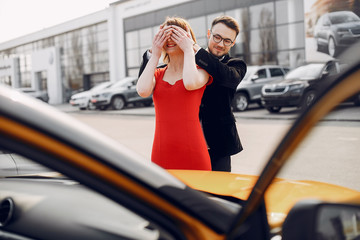 Couple in a car salon. Family buying the car. Elegant woman with her husband.