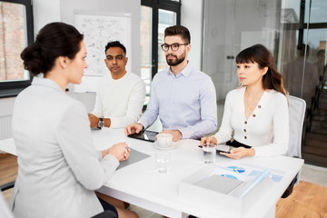 Fototapeta premium new job, hiring and employment concept - international team of recruiters having interview with female employee at office