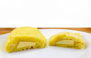 Brazilian pamonha on white background, typical dessert of the rural cities of Brazil. Sweet corn with cheese served in the straw. Rural sweets made in the states of Minas Gerais and Goiais.