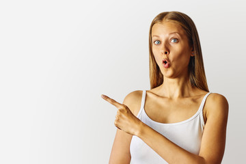 Surprised woman pointing to the left with forefinger