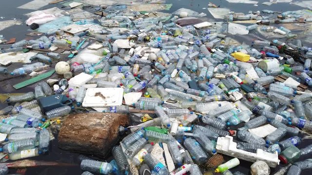 Plastic pollution trash in ocean with different kinds of garbage - plastic bottles, bags, wastes floating in water. Sea ocean water pollution concept. Plastic pollution crisis