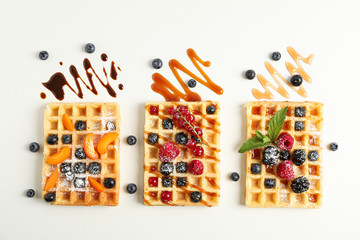 Flat lay composition with belgian waffles and different toppings, top view