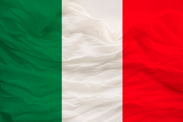 The national flag of the country of Italy on gentle silk with wind folds, travel concept, immigration, politics, copy space, close-up