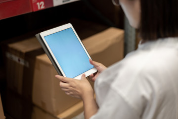 worker hand holding pad for check order pick time in smart factory warehouse