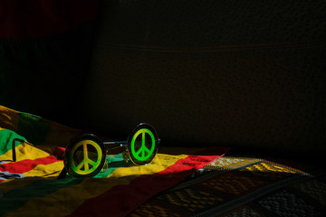 Vintage sunglasses with a symbol of pacifist movement on a colored surface  in a partially...