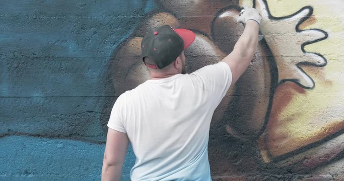 Graffiti artist with aerosol spray bottle