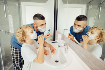 Cute blonde boy holding a razor in the hand