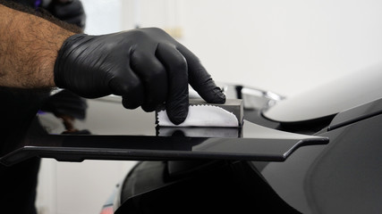 Staff wear Chemical protective clothing at work. Automobile industry. Car wash and coating business with ceramic coating.Spraying the varnish to the car. Concept of: Car protective, Service, Shine.