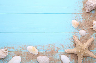 Starfish and seashells with sand on a wooden background. Summer concept