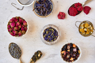 Different herbal and fruit dry teas on marble table. Top view flat lay with copy space