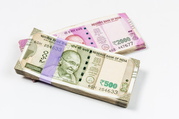 Bundles of Indian 500 and 2000 rupee notes in white background