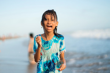 beach lifestyle portrait of young beautiful and happy 7 or 8 years old Asian American mixed child girl with wet hair enjoying holidays playing in the sea having fun