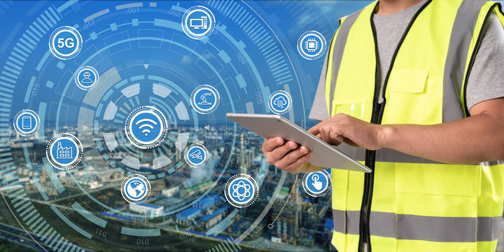worker working on pad with oil and gas refinery background,Smart factory concept.