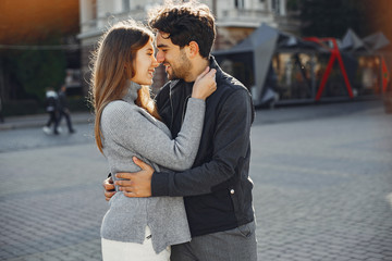 Fototapeta premium Cute couple in a spring city. Lady with long hair. Man in a black jacket
