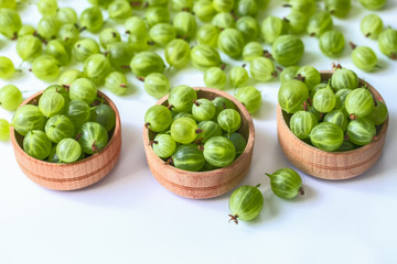 green gooseberry in wooden bowls close-up. background with gooseberry.