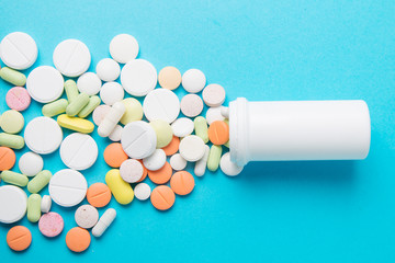 Medicines pills, drugs and antibiotics on a blue background. Medicine and health care.