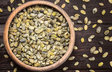 pumpkin seeds in a bowl on the table top view. pumpkin seeds and copy space. flat lay.