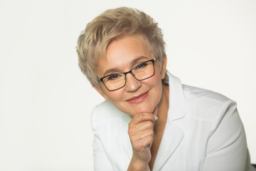 portrait of an adult woman with a short haircut wearing glasses in a white jacket on a white background