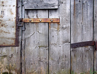 Part of a wooden barn door with a padlock as a background.