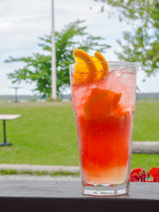 summer refreshing coctails and beautiful view. Orange alcoholic coctail or a lemonade with lemon and orange