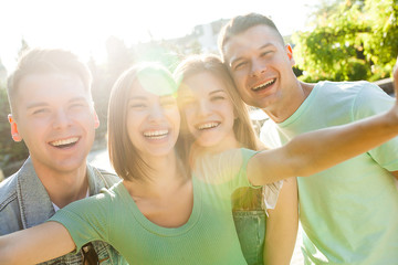 Group of cheerful smiling people making selfie. Friends making a shot on the smartphone. People making a picture on the cellphone.