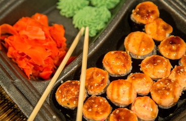 Set of baked rolls in a plastic box. Food delivery from sushi restaurant