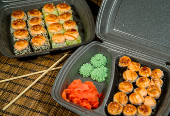 Set of baked rolls in a plastic box. Food delivery from sushi restaurant