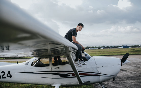 man sitting on white airplane wing