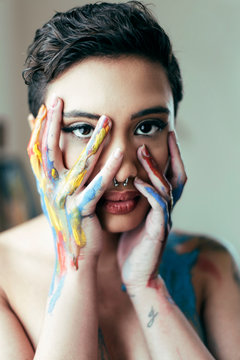 painted hands by face