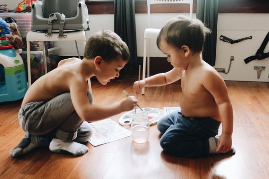 Two toddler boys painting with watercolors