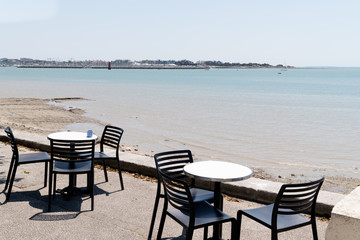 Fototapeta na wymiar Table and chairs on coast of La Rochelle old port bay in France