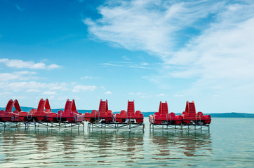 Travel background of lots of red pedal boats on a pier at lake Balaton in Hungary