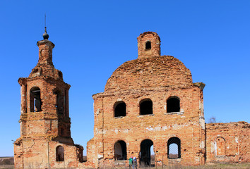A dilapidated old brick building, against a background of a bright day sky