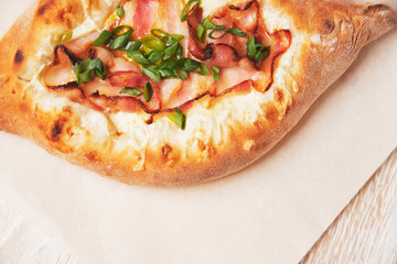 Pie with bacon and cheese close-up on a light background