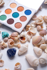 Obraz na płótnie Canvas fashion summer eye palettes with natural shells and gemstones around background. close up