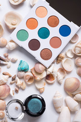 fashion summer eye palettes with  natural shells and gemstones around background. close up
