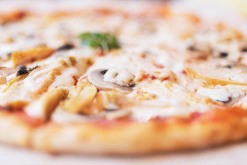 Pizza with chicken and mushrooms close-up in defocus
