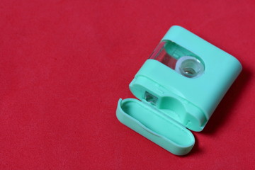 Floss container. Against the background of coral color. View from above.