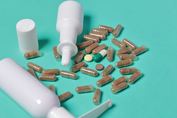Gelatin pills and tablets of different colors. Sprays of oral and nasal sprays. Medicines scattered...