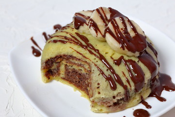 White plate with banana magcake. On a white background.