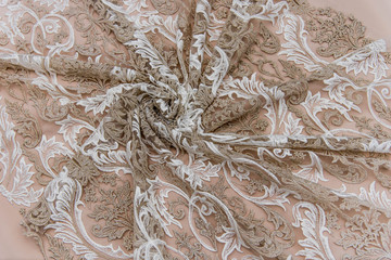 Texture lace fabric. lace on white background studio. thin fabric made of yarn or thread. a background image of ivory-colored lace cloth. White and beige lace on beige background.