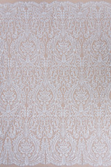 Texture lace fabric. lace on white background studio. thin fabric made of yarn or thread. a background image of ivory-colored lace cloth. White lace on beige background.