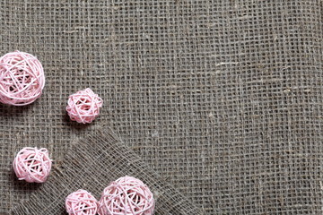 Coarse linen fabric. On it are rattan balls.