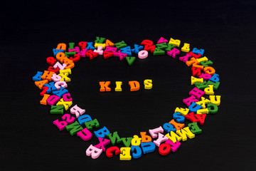 Letter in the form of hearts on black wood background