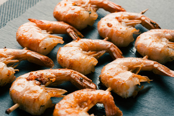 Three rows of fried shrimp skewers side view