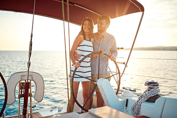 Romantic couple on boat together enjoy at sunset on vacation.